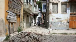Warga mengamati puing bangunan yang hancur setelah gempa bumi di pulau Lesbos, Yunani Timur, Senin (12/6). Gempa 6,3 SR itu mengakibatkan kerusakan pada beberapa rumah dan sejumlah bangunan di pulau Lesbos. (Manolis Lagoutaris/InTime News via AP)