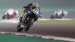 Pebalap Movistar Yamaha, Valentino Rossi, memacu motornya saat MotoGP Qatar. Meski memulai start dari posisi ke-10, namun The Doctor berhasil meraih podium dengan finish di urutan ketiga. (AFP/Karim Jaafar)