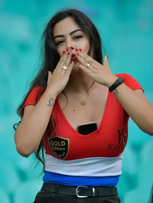 Model Larissa Riquelme berpose dengan memberi isyarat ciuman sebelum pertandingan Copa America 2019 antara Paraguay dengan Kolombia di Fonte Nova Arena, Salvador, Brasil, Minggu (23/6/2019). Kehadiran wanita berusia 34 tahun tersebut  untuk mendukung Timnas Paraguay berlaga. (Raul ARBOLEDA/AFP)