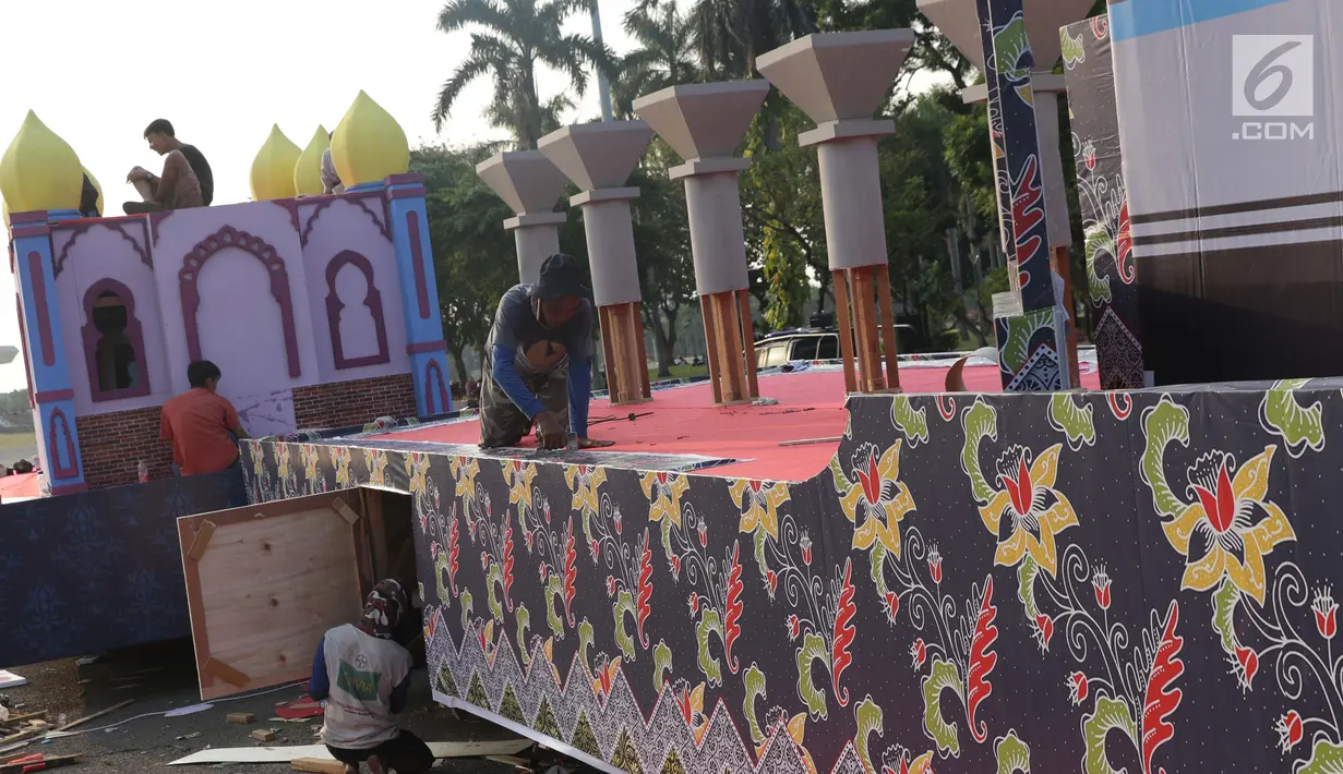 Pekerja menyelesaikan pembuatan miniatur masjid di atas kendaraan hias di kawasan Monas, Jakarta, Jumat (28/6/2019). Kendaraan hias tersebut dipersiapkan untuk mengikuti Jakarnaval 2019 yang merupakan puncak perayaan HUT ke-492 DKI Jakarta, Minggu (30/6). (Liputan6.com/Helmi Fithriansyah)