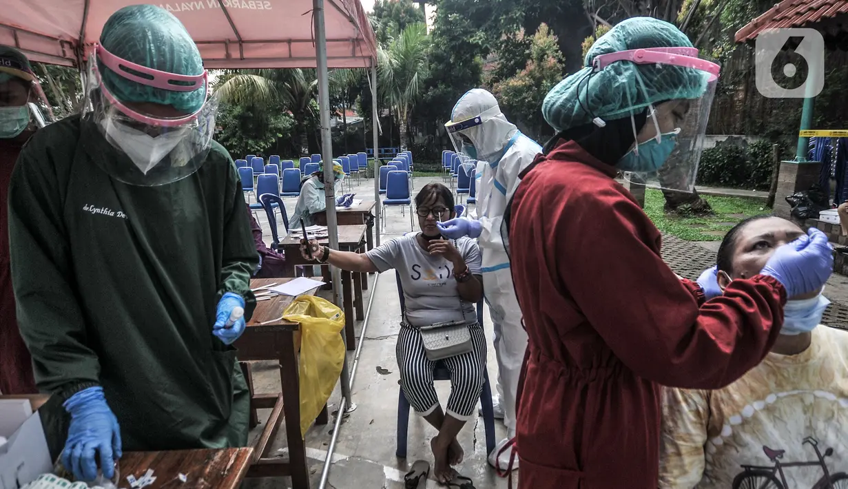 Warga menjalani tes usap PCR di Taman Pintar, Kayu Putih, Pulogadung, Jakarta Timur, Selasa (8/6/2021). Warga RW 09 dan 10 Kelurahan Kayu Putih kembali menjalani tes usap PCR guna mengantisipasi penyebaran COVID-19 di wilayah mereka. (merdeka.com/Iqbal S. Nugroho)