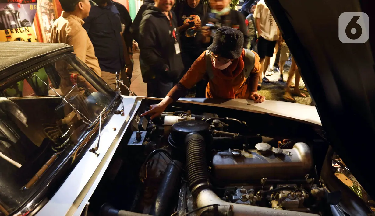 Pengunjung melihat mobil antik yang dipamerkan di Museum Angkut, Kota Batu, Jawa Timur, Kamis (15/12/2022). Museum Angkut merupakan museum transportasi dan tempat wisata modern. (Liputan6.com/Herman Zakharia)