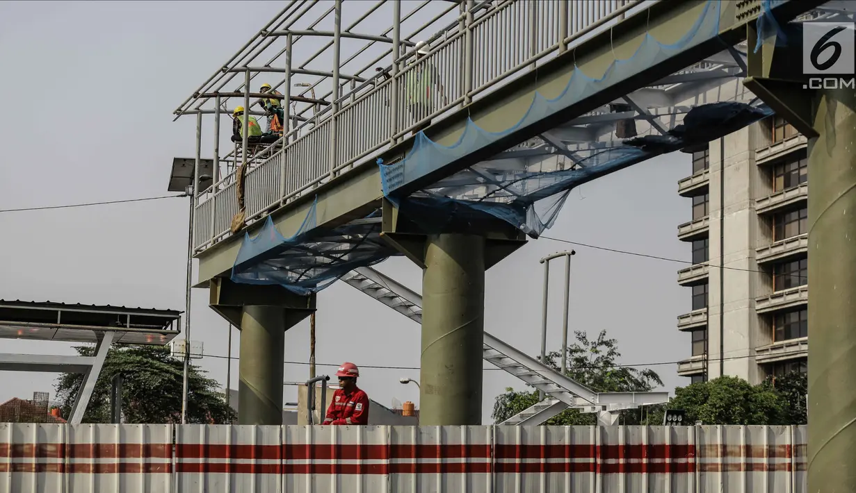 Pekerja menyelesaikan pembangunan halte busway BNN di Kawasan Cawang Jakarta, Jumat (2/3). Pembangunan halte baru tersebut guna menggantikan halte BNN yang lama akibat pembangunan proyek LRT. (Liputan6.com/Faizal Fanani)