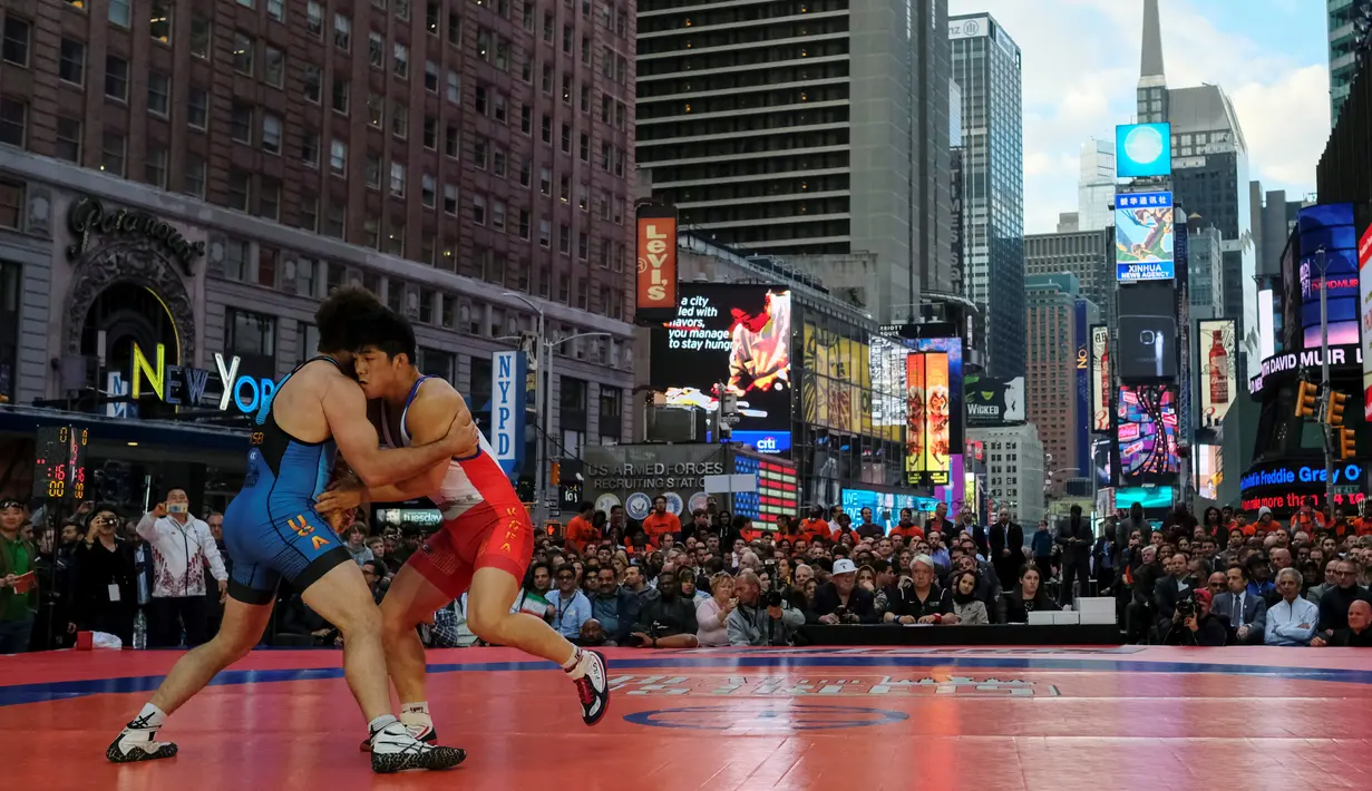 Pegulat dari AS, Andy Bisek (biru) melawan Kim Hyeon-Woo dari Korea Selatan pada kejuaraan gulat Beat the Streets, Times Square, New York (19/5). Turnamen ini diikuti pegulat profesional sebagai persiapan Olimpiade di Brasil.  (REUTERS/Adrees Latif)