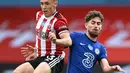 Pemain Sheffield United, Ben Osborn berebut bola gelandang Chelsea, Jorginho pada pekan ke-35 Liga Inggris di Bramall Lane, Minggu (12/7/2020) dini hari WIB. Chelsea dihajar 0-3 oleh Sheffield United. (Shaun Botterill/Pool via AP)