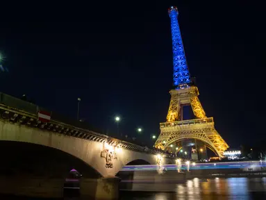 Sebuah foto menunjukkan Menara Eiffel di Paris diterangi dengan warna bendera nasional Ukraina, pada 9 Mei 2022. Memperingati Hari Eropa, Menara Eiffel memproyeksikan bendera Ukraina sebagai solidaritas untuk rakyat Ukraina di tengah invasi Rusia. (AFP)