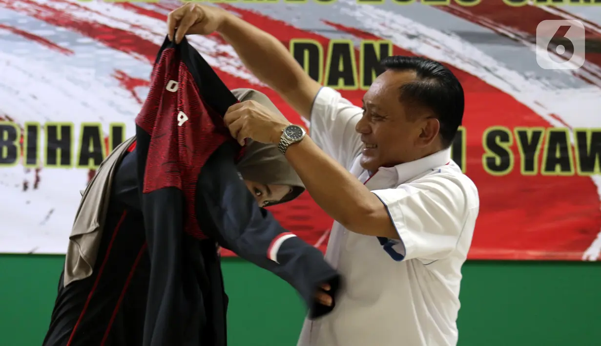 Ketua Umum PBVSI, Imam Sudjarwo (kanan) menyematkan jaket kontingen kepada Kapten Timnas Voli Putri Indonesia, Wilda Siti Nurfadilah Sugandi saat seremoni pelepasan kontingen menuju ajang SEA Games 2023 Kamboja di Padepokan Voli Jenderal Polisi Kunarto, Sentul, Jawa Barat, Sabtu (29/4/2023). (Liputan6.com/Helmi Fithriansyah)