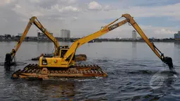 Sejumlah alat berat dikerahkan untuk mengeruk sampah di Waduk Pluit, Jakarta, Kamis (30/4/2015). Pengerukan waduk pluit  dilakukan selain untuk mengurangi sampah - sampah di waduk juga untuk keindahan waduk. (Liputan6.com/JohanTallo)