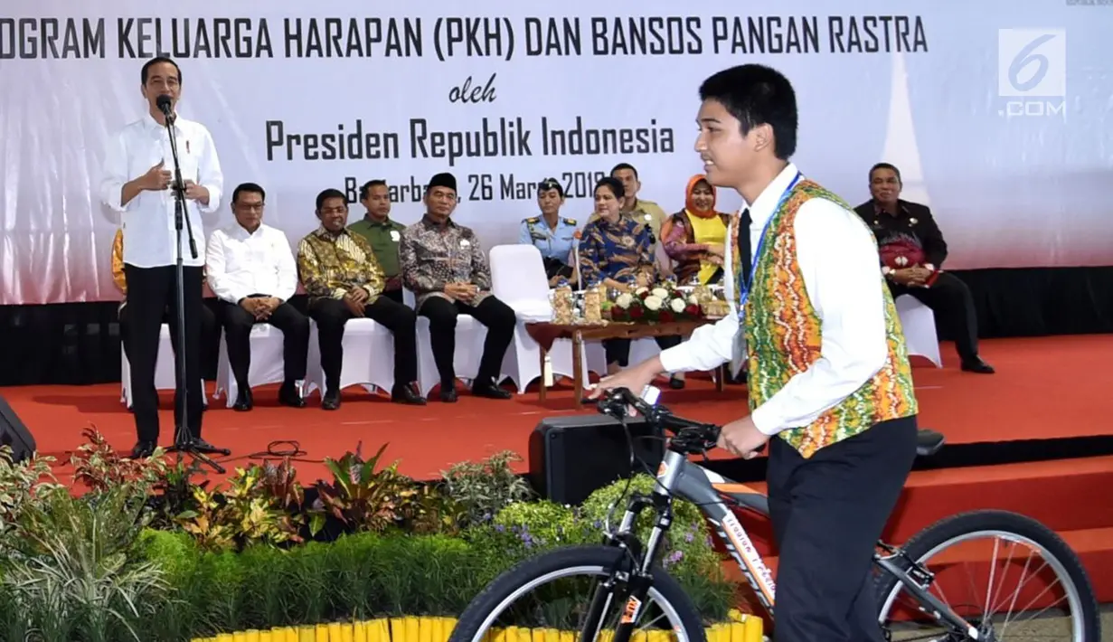 Seorang siswa menerima hadiah sepeda usai menjawab pertanyaan Presiden Jokowi dalam acara penyerahan KIP dan PKH di Kota Banjarbaru, Kalimantan Selatan (26/3). (Liputan6.com/Pool/Biro Setpres)