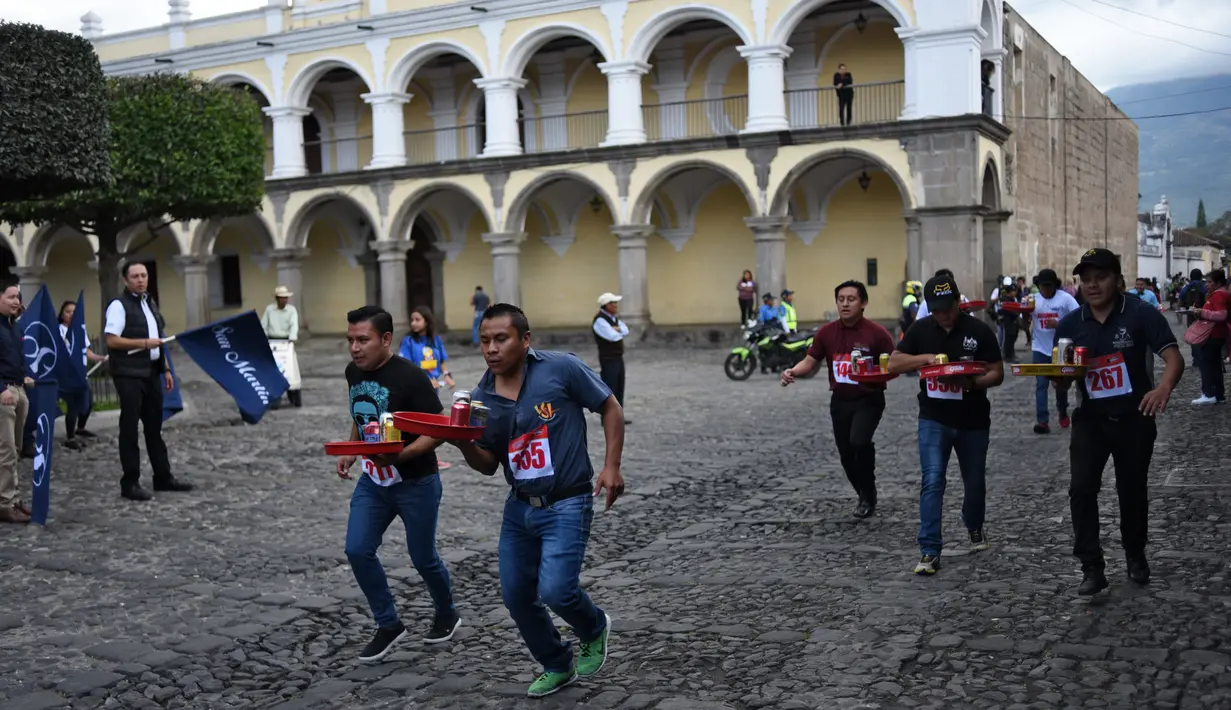 Pramusaji dari berbagai restoran berpartisipasi dalam Waiters Race ke-16 di Antigua, barat daya Ibu Kota Guatemala City, Rabu (14/11). Peserta diminta unjuk kebolehan menggunakan satu tangan membawa nampan berisi minuman. (JOHAN ORDONEZ/AFP)