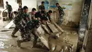 Meski fasilitas fisik mulai membaik, banyak peralatan medis yang ada di Rumah Sakit Daerah Aceh Tamiang dilaporkan rusak. Tampak dalam foto, personel Tentara Nasional Indonesia (TNI) dari YONIF TP 853/BRB, Aceh Timur, membersihkan lumpur di Rumah Sakit Daerah di Aceh Tamiang, pada 16 Desember 2025, setelah banjir bandang sekitar tiga minggu lalu. (Yasuyoshi Chiba/AFP)