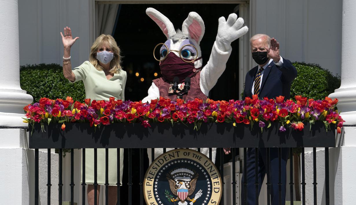 Presiden Joe Biden bersama Ibu Negara Jill Biden dan Kelinci Paskah melambaikan tangan dari balkon Ruang Biru, Gedung Putih, Washington, Amerika Serikat, Senin (5/4/2021). Gedung Putih kembali meniadakan tradisi Easter Egg Roll menyusul pandemi COVID-19 yang sedang berlangsung. (AP Photo/Evan Vucci)