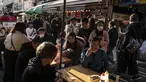 Orang-orang menunggu untuk makan makanan laut di area "pasar ikan luar" Tsukiji di Tokyo pada 28 Desember 2022. Menjelang liburan Tahun Bar, turis asing dan penduduk lokal berkunjung ke pasar itu untuk menikmati hidangan bermacam makanan laut. (AFP/Richard A. Brooks)