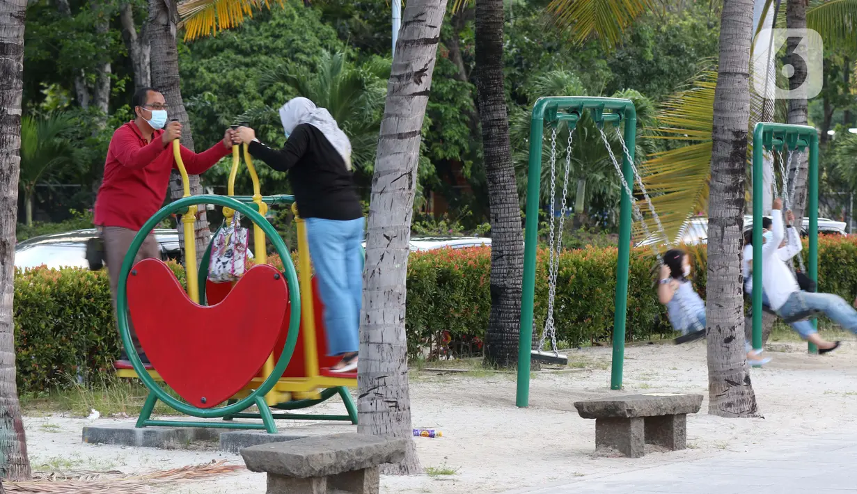 Pengunjung bersama anak-anak menikmati suasana pantai di Taman Impian Jaya Ancol, Jakarta, Kamis (29/10/2020). Libur panjang di masa pemberlakuan PSBB transisi Jakarta dimanfaatkan warga untuk mengunjungi lokasi-lokasi wiisata. (Liputan6.com/Helmi Fithriansyah)