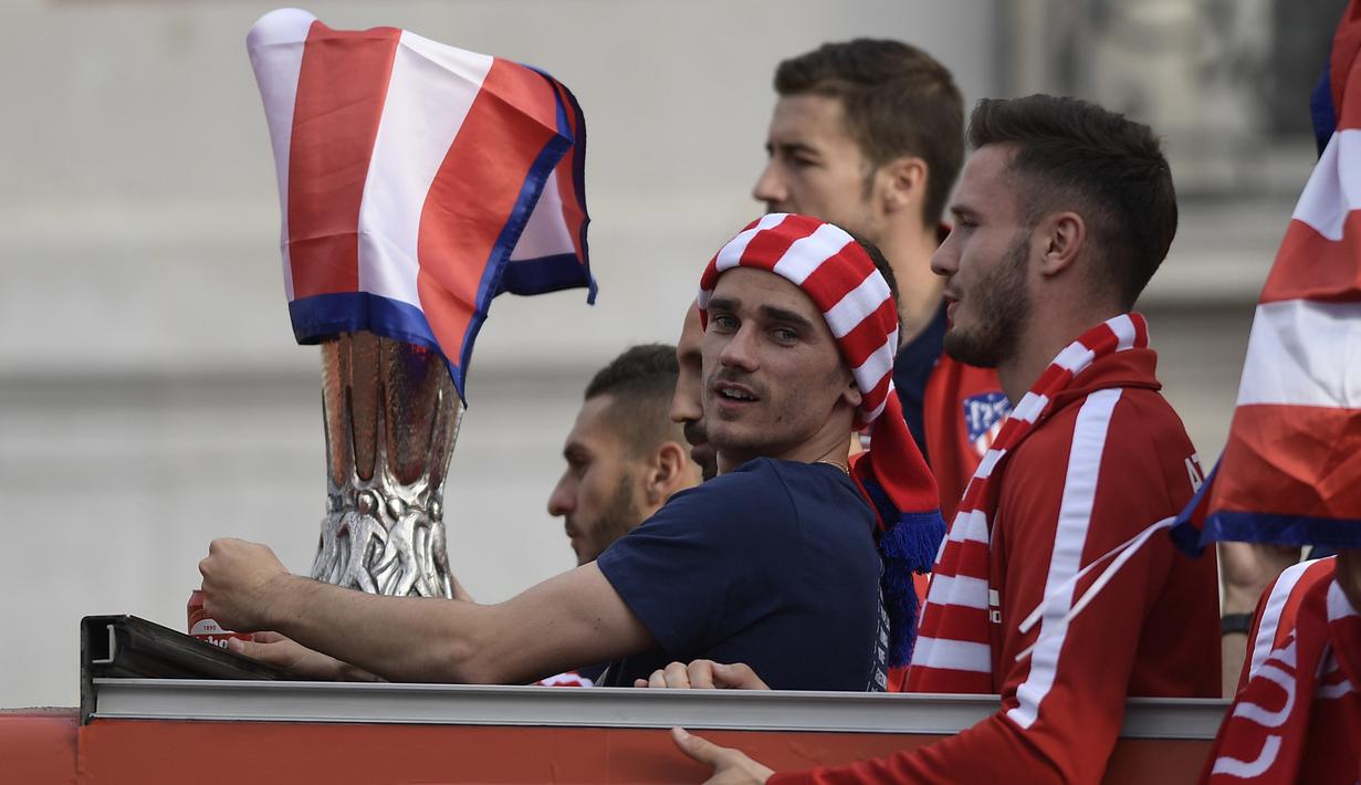 Striker Atletico Madrid, Antoine Griezmann, mengikuti konvoi perayaan gelar Liga Europa di Madrid, Jumat (18/5/2018). Kota Madrid menjadi merah saat perayaan gelar juara Atletico. (AFP/Oscar Del Pozo)