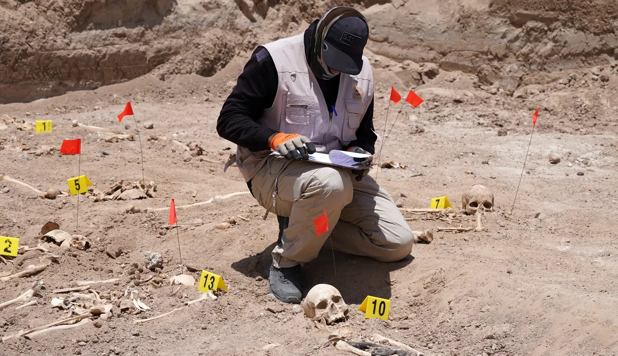 <p>Seorang ahli forensik yang bekerja untuk otoritas Irak, bekerja di sebuah kuburan massal di mana sisa-sisa jenazah manusia digali, dekat kota selatan Najaf, pada 14 Mei 2022. Kuburan massal itu, pertama kali ditemukan pada April tahun ini, diyakini menampung puluhan orang yang kemungkinan besar tewas di bawah mendiang diktator Saddam Hussein, kata seorang pejabat. (AFP)</p>