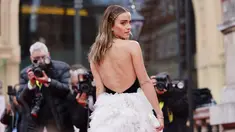 Aktris Inggris Emma Watson berpose di karpet merah saat tiba di BAFTA British Academy Film Awards di Royal Albert Hall, di London (13/3/2022). Emma Watson tampil memesona dengan atasan halter-neck hitam dan rok tulle krem. (AFP/Tolga Akmen)