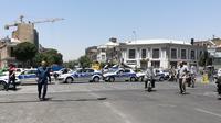 Sejumlah mobil polisi berdatangan usai terjadi penyerangan bersenjata di parlemen Iran,  Rabu (7/6). Tiga pria bersenjata dilaporkan melakukan penyerangan di dalam gedung parlemen Iran dengan menggunakan senjata api. (AFP/ATTA KENARE)