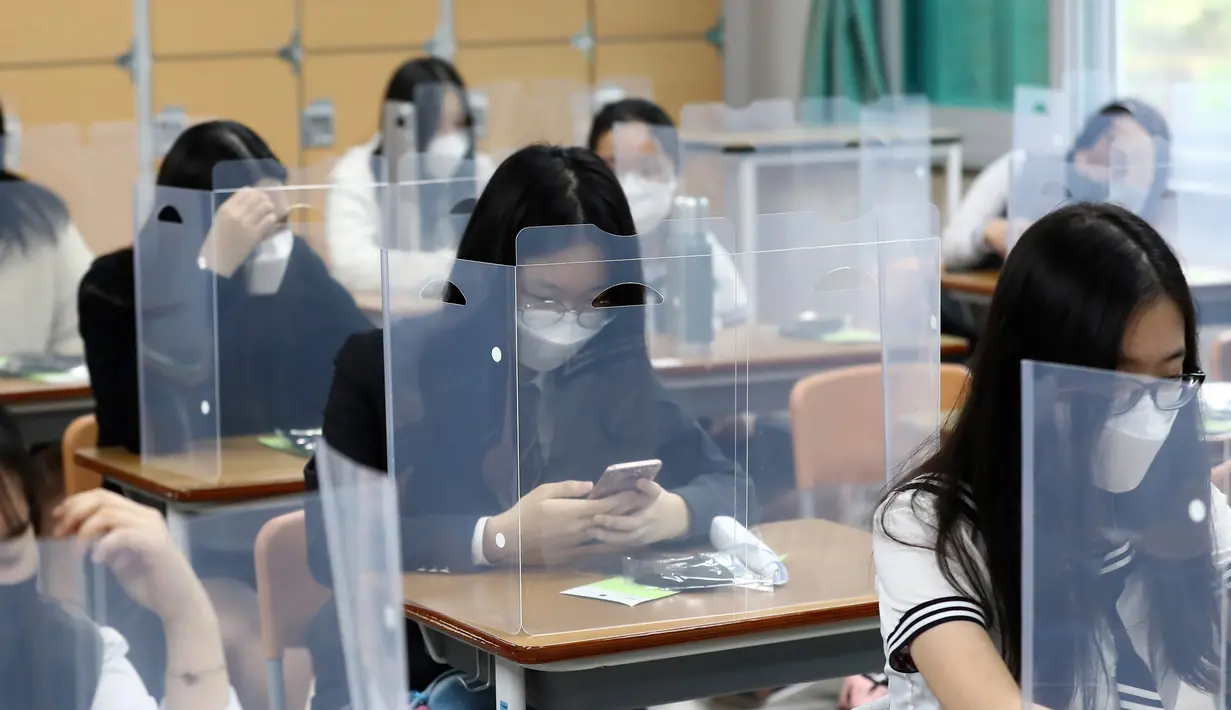 Siswa menunggu kelas dimulai dengan pembatas plastik di atas meja di Jeonmin High School di Daejeon, Korea Selatan, Rabu (20/5/2020). Hingga kini, Korea Selatan memiliki 11.110 kasus corona dengan 263 kematian dan 10.066 pasien sembuh. (Kim Jun-beom/Yonhap via AP)