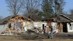 Alan Freeman dan Brandon Schmidt melihat kerusakan rumah mereka setelah tornado menghantam Clarksdale, Mississipi, Kamis (24/12). Badai tornado menerjang wilayah Amerika Serikat bagian selatan dan menewaskan 11 orang.  (REUTERS/ Justin A. Shaw)