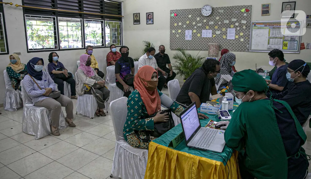 Sejumlah tenaga pendidik sebelum mengikuti vaksin COVID-19 di SMP 216, Jakarta Pusat, Selasa (6/4/2021). Menurut Menteri Kesehatan Budi Gunadi Sadikin, pemerintah akan memprioritaskan kelompok lansia dan juga tenaga pengajar dalam vaksinasi kali ini. (Liputan6.com/Faizal Fanani)