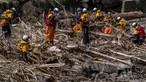 Petugas penyelamat mencari orang-orang yang hilang dalam puing-puing yang hanyut akibat banjir di sungai Tsukada setelah hujan lebat di kota Wajima, prefektur Ishikawa pada Senin 23 September 2024. (Yuichi YAMAZAKI/AFP)