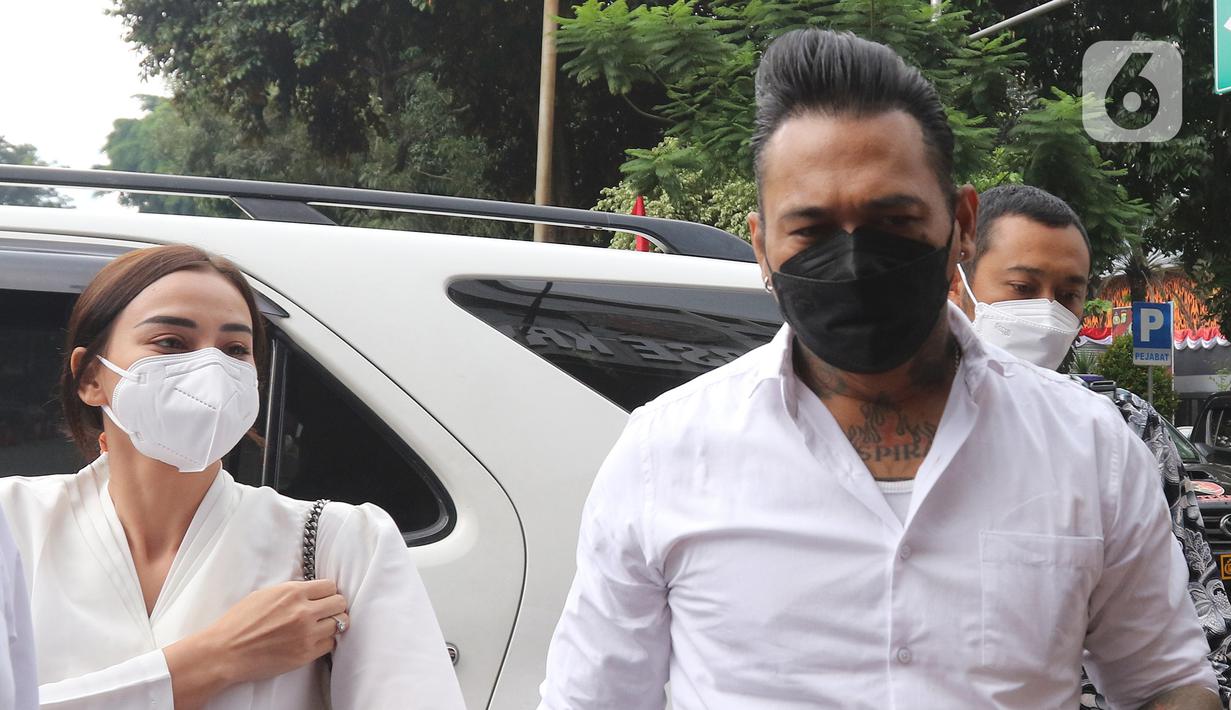 Musikus I Gede Ary Astina alias Jerinx didampingi istrinya, Nora Alexandra, tiba di Polda Metro Jaya, Jakarta, Sabtu (14/08/2021). Kedatangan Jerinx untuk menghadiri proses mediasi dengan pegiat media sosial Adam Deni terkait kasus dugaan pengancaman yang menjeratnya. (Liputan6.com/Herman Zakharia)