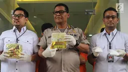 Kabid Humas Polda Metro Jaya, Kombes Pol Argo Yuwono (tengah)menunjukkan barang bukti beserta tersangka kasus narkotika jenis sabu di Polda Metro Jaya, Jakarta, Rabu (16/1). (Liputan6.com/Immanuel Antonius)