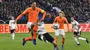 Bek Belanda, Virgil Van Dijk, berebut bola dengan penyerang Jerman, Thomas Mueller, pada laga UEFA Nations League di Veltins Arena, Gelsenkirchen, Senin (19/11/2018). Kedua tim bermain imbang 2-2. (AP/Martin Meissner)