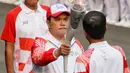 Ketua Inasgoc Erick Thohir saat menyalakan api obor Asian Games 2018 ke Presiden Joko Widodo sebelum upacara penurunan Bendera Merah Putih di Istana Negara Jakarta, Jumat (17/8). (Liputan6.com/Pool/Eko)