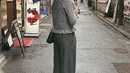 Aaliyah Massaid tampil mengenakan pakaian serba abu-abu. Dari atasan cardigan dipadukan celana panjang. Ia pun membawa tas Dior dan mengenakan sneakers pink. [@aaliyah.massaid]