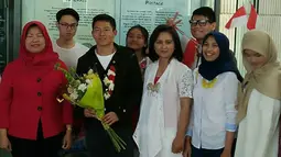 Pebalap F1 pertama asal Indonesia, Rio Haryanto menerima bunga saat disambut kedatangannya oleh komunitas masyarakat Indonesia di Kanada. (Media Rio Haryanto)
