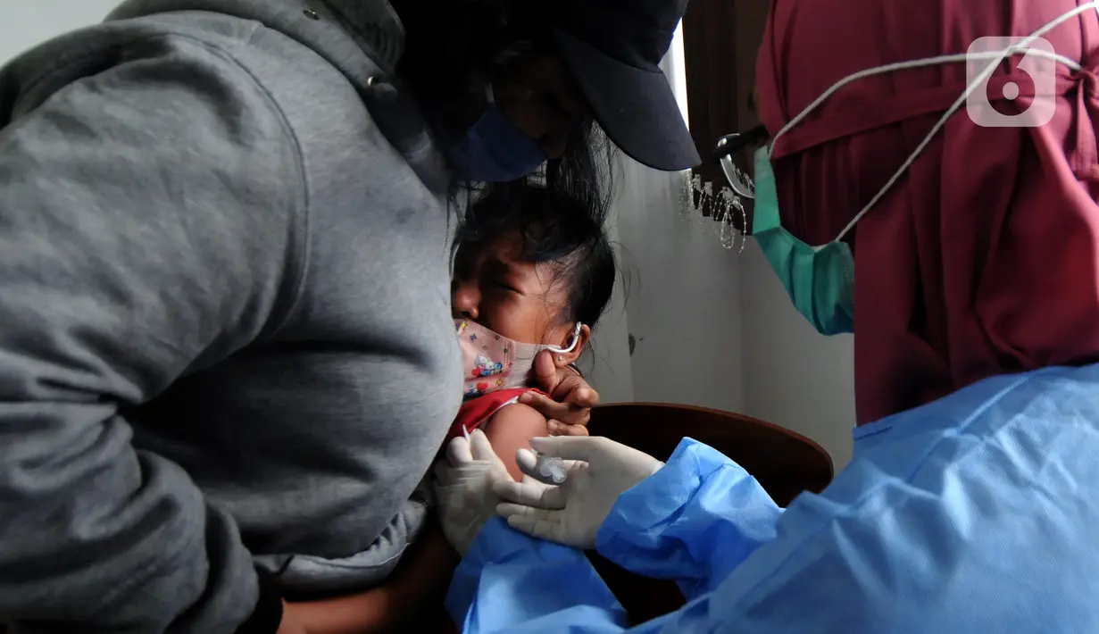 Petugas kesehatan menyuntikkan vaksin COVID-19 kepada siswa di SDN 02 Ciater, Tangerang Selatan, Selasa (14/12/2021). Mulai Hari ini, 11 provinsi di Indonesia secara serentak melaksanakan vaksinasi COVID-19 dengan sasaran anak berusia 6 hingga 11 tahun. (merdeka.com/Arie Basuki)