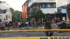 Seorang petugas berjaga dekat garis polisi yang terpasang di lokasi ledakan di kawasan Ruko Grand Wijaya, Kebayoran Baru, Jakarta Selatan, Kamis (12/7). Polisi memastikan ledakan bukan berasal dari bahan peledak atau bom. (Liputan6.com/Ady Anugrahadi)