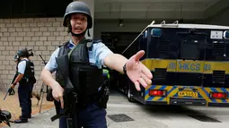 Polisi bersenjata lengkap menjaga ketat saat mobil yang membawa Rurik Jutting ke Pengadilan Tinggi di Hong Kong, Tiongkok (24/10). Jutting mengaku menyiksa korbannya selama tiga hari dan merekam aksinya. (Reuters/Bobby Yip)