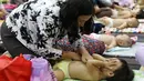 Seorang ibu memijat anaknya dalam acara pijat massal bayi di Gedung Kementerian Kesehatan, Jakarta, Selasa (7/11). Acara dalam rangka menyambut Hari Kesehatan Nasional ini diikuti 300 bayi dan anak bawah dua tahun. (Liputan6.com/Immanuel Antonius)
