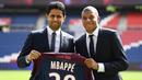 Penyerang PSG, Kylian Mbappe (kanan) bersama Presiden PSG, Nasser Al-Khelaifi saat perkenalan di Parc des Princes stadium, Paris, (6/9/2017). Mbappe dipinjam PSG dari Monaco dengan opsi permanen sebesar 180 juta euro tahun berikutnya. (AFP/Franck Fife)