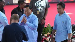 Calon presiden dengan nomor urut 2, Prabowo Subianto (kiri) menyapa Ketua Komisi Pemilihan Umum Hasyim Asyari saat berjalan bersama pasangannya Gibran Rakabuming Raka, (kanan) setibanya untuk menghadiri "Deklarasi Kampanye Pemilu Damai" di Gedung Komisi Pemilihan Umum (KPU), Jakarta, Senin, 27 November 2023. (AP Photo/Tatan Syuflana)