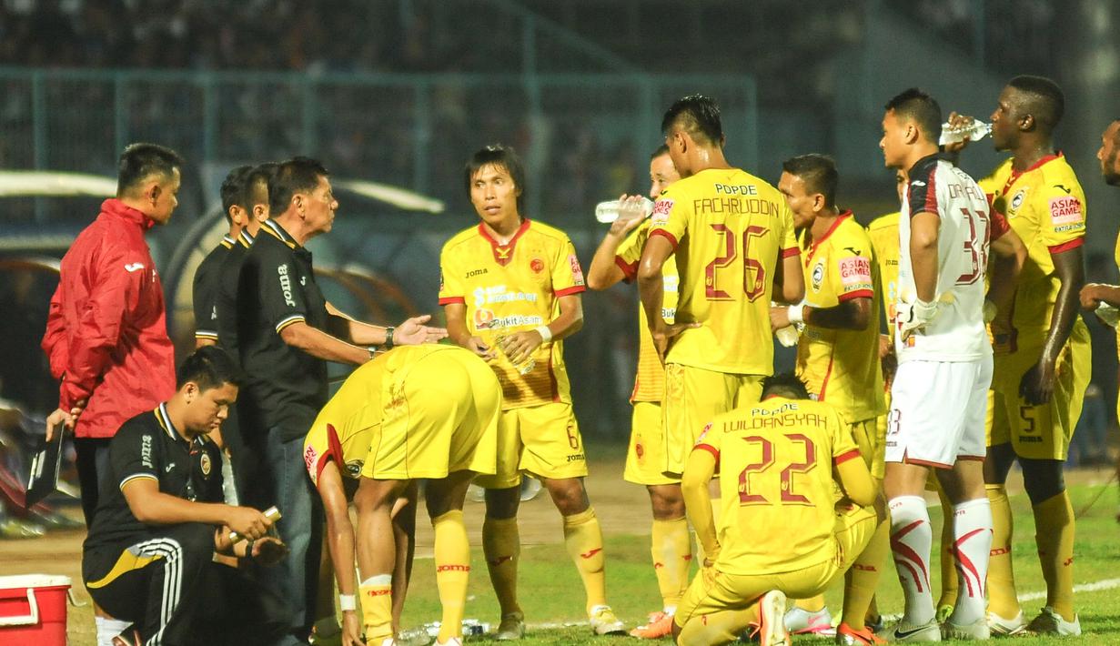 Para Pemain Sriwijaya FC serius mendengarkan instruksi pelatih Beni Dolo pada Laga Semifinal leg pertama Piala Presiden di Stadion Kanjuruhan, Malang, Sabtu (3/10/2015). Sriwijaya menahan imbang Arema 1-1. (Bola.com/Kevin Setiawan)