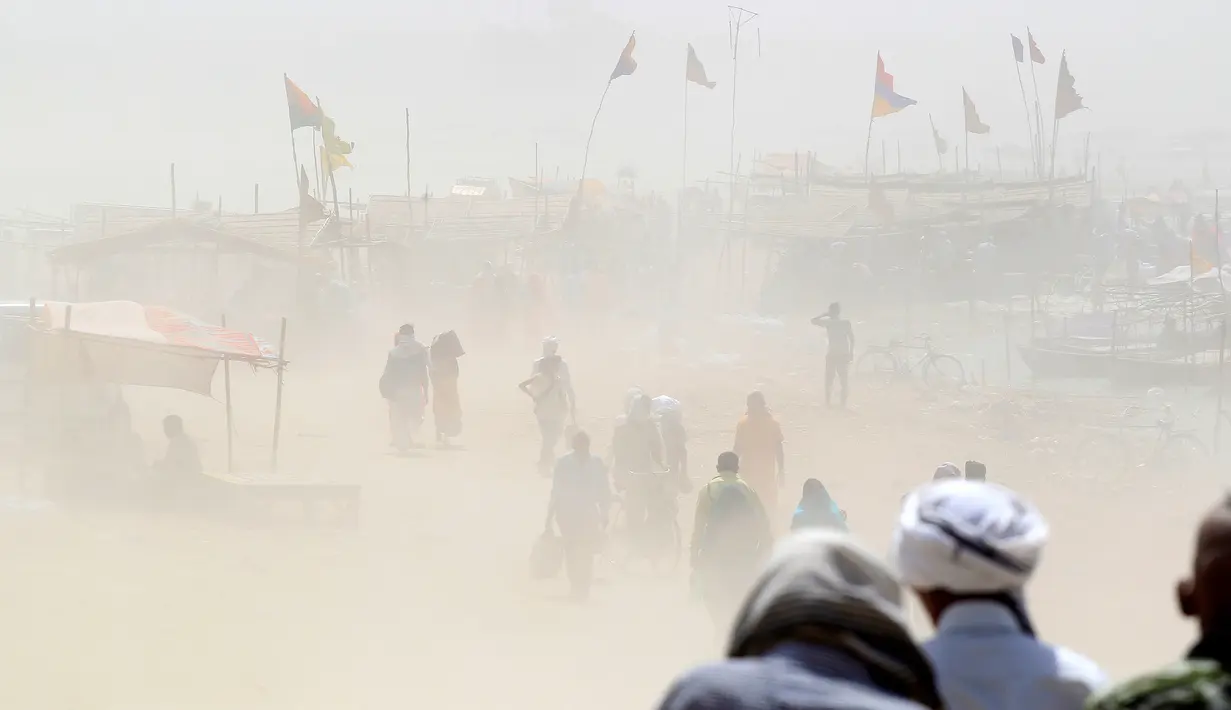 Sejumlah warga berjalan melintasi badai pasir di tepi sungai Gangga di Allahabad, India, Selasa (12/4/2016).  (REUTERS/Jitendra Prakash)