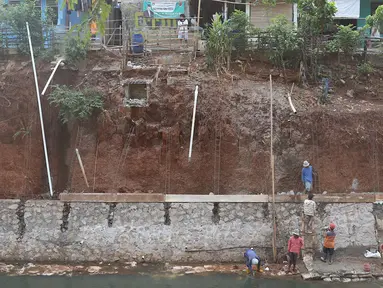 Pekerja membangun turap di bantaran Kali Cijantung, Jakarta Timur, Kamis (11/10). Pembangunan turap bertujuan mencegah longsor yang dapat membahayakan warga sekitar. (Liputan6.com/Immanuel Antonius)