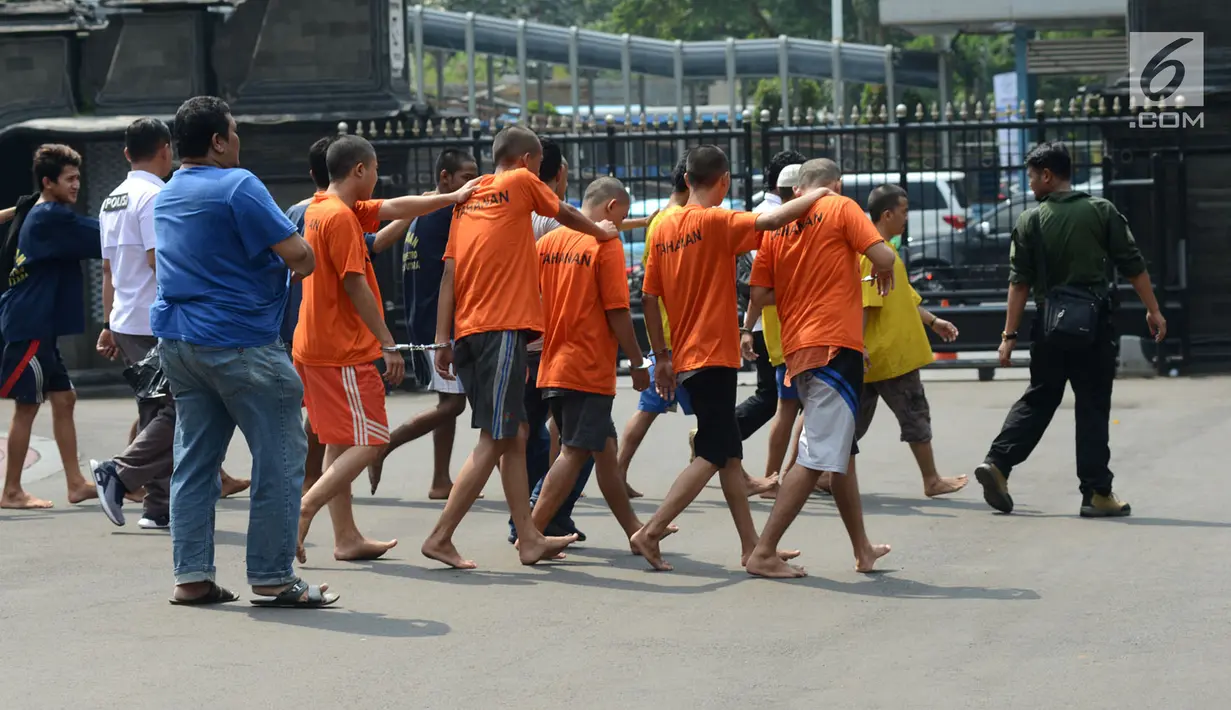 Polisi menggiring para tersangka saat gelar perkara kejatahan wilayah Jabodetabek di Polda Metro Jaya, Jakarta, Jumat (15/3). Polisi mengamankan barang bukti senjata tajam dan senjata api dari tangan para tersangka. (merdeka.com/Imam Buhori)