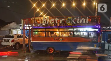 Penampakan kafe yang menggunakan angkutan metromini di Bekasi, Jawa Barat, Kamis (15/4/2021). Kafe ini berinovasi di tengah pandemi COVID-19 dengan menggunakan armada metromini yang sudah tidak terpakai sebagai tempat makan pengunjung. (Liputan6.com/Herman Zakharia)