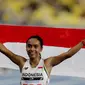 Pelari Indonesia Triyaningsih membawa bendera merah putih setelah mencapai garis finis dalam cabang olahraga atletik nomor lari 10 km putri SEA Games 2017 di Stadion Nasional Bukit Jalil, Malaysia, Kamis (24/8). (Liputan6.com/Faizal Fanani)