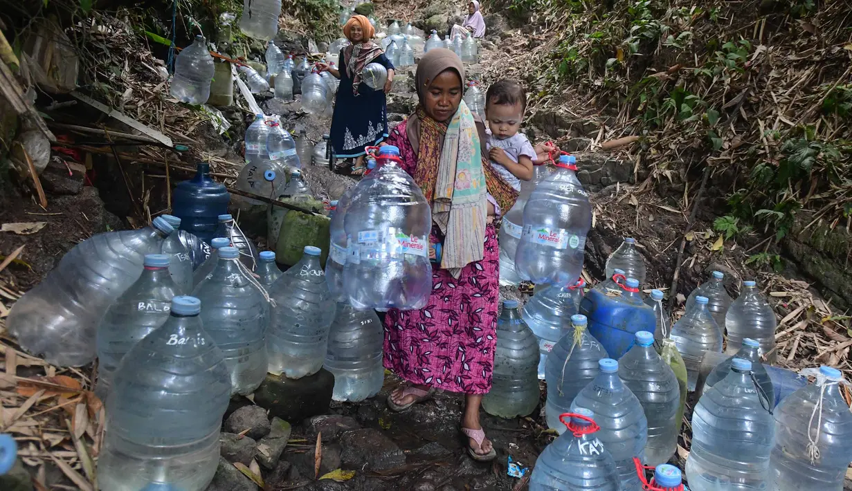 Warga berjalan untuk mengambil air untuk minum dan kebutuhan mck rumah  di sumber mata air Sumur Bendung, Gunung Batur, Kota Cilegon, Banten, Minggu, (15/7/2026). (KLY/Arie Basuki)