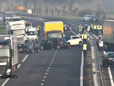Petugas darurat berada di lokasi tabrakan beruntun di Jalan D12 antara La Roche-sur-Yon dan Les Sables d'Olonne, sebelah barat Prancis, Selasa (20/12). Kecelakaan yang melibatkan sekitar 50 kendaraan itu menewaskan 5 orang. (JEAN-FRANCOIS MONIER/AFP)