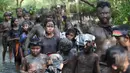 Warga berjalan menyusuri hutan mangrove saat mengikuti tradisi mandi lumpur atau mebuug-buugan di Desa Kedonganan, Denpasar, Bali, Jumat (8/3). Saat mengikuti tradisi mebuug-buugan warga diwajibkan memakai busana adat. (Sonny Tumbelaka/AFP)