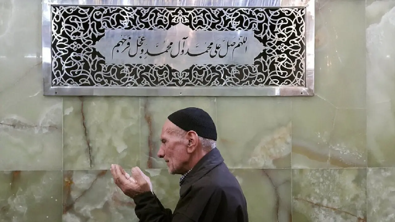 Muslim membaca sholawat di dekat kaligrafi bertuliskan sholawat (Wikimedia Commons)