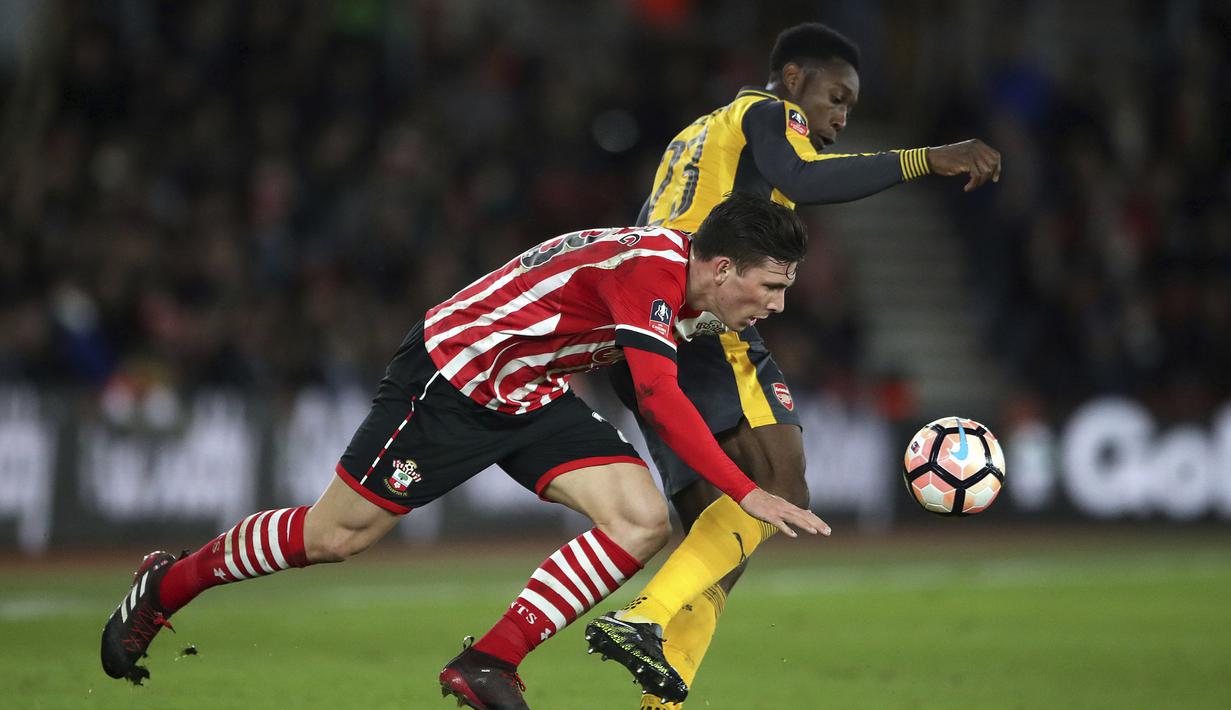 Pemain Arsenal, Danny Welbeck (kanan) berebut bola dengan pemain Southampton,  Pierre-Emile Hojbjerg pada putaran keempat Piala FA musim 2016-2017 di St Mary's Stadium,  (28/1/2017. Arsenal menang 5-0. (Nick Potts/PA via AP)