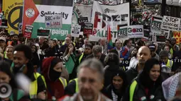 Para pengunjuk rasa mengibarkan bendera dan poster saat demonstrasi pro-Palestina di London, Sabtu, 21 Oktober 2023. (AP Photo/David Cliff)